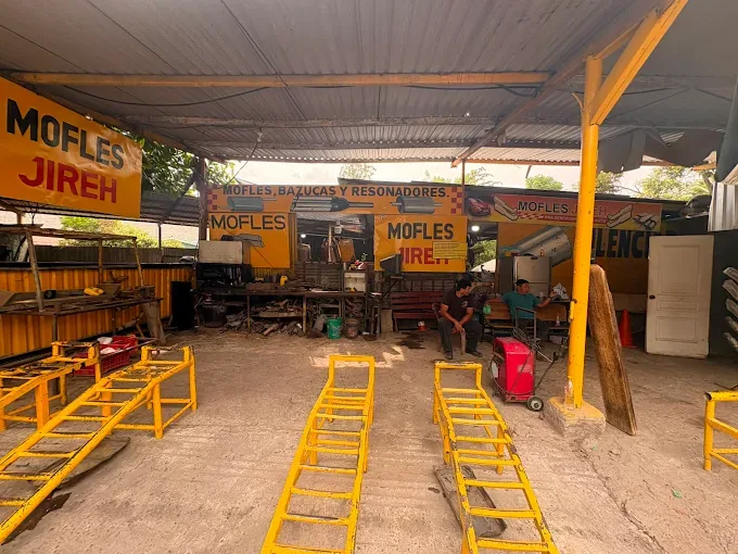 Interior del taller con rampas amarillas para subir los carros